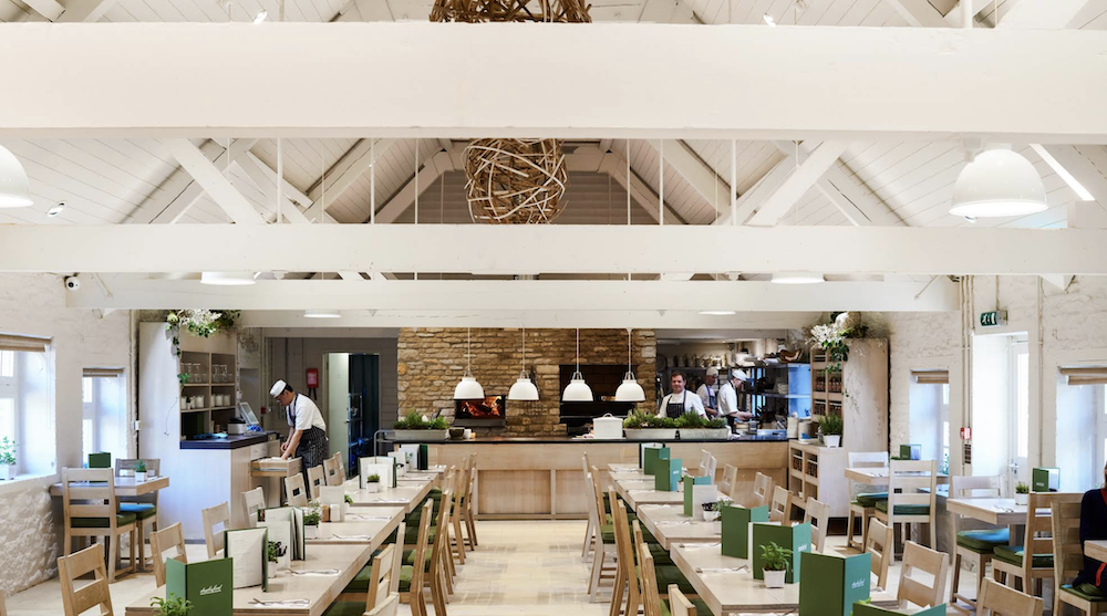 The Trough restaurant at Daylesford with long tables and open kitchen