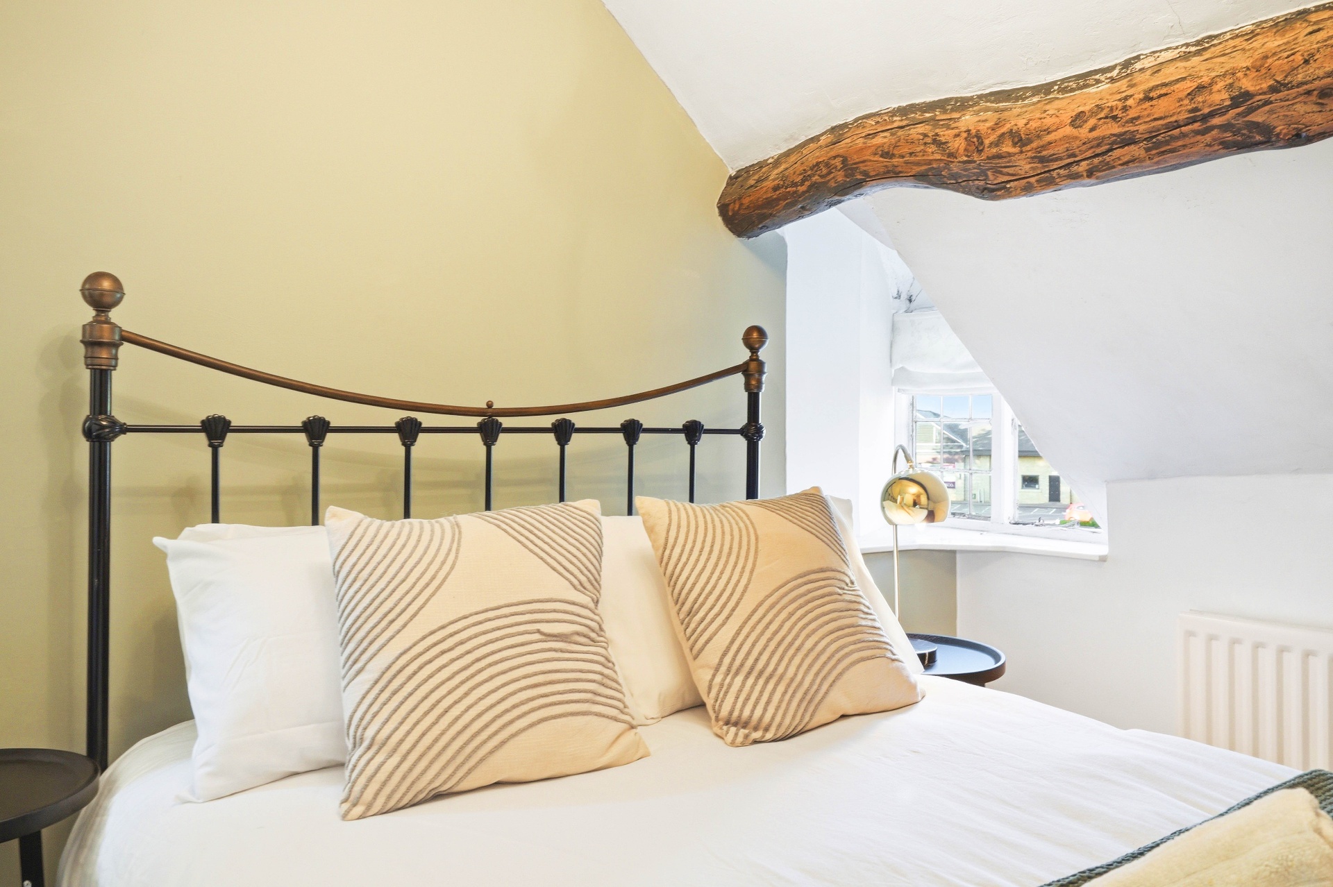 Bedroom Three close view with iron headboard and cottage window