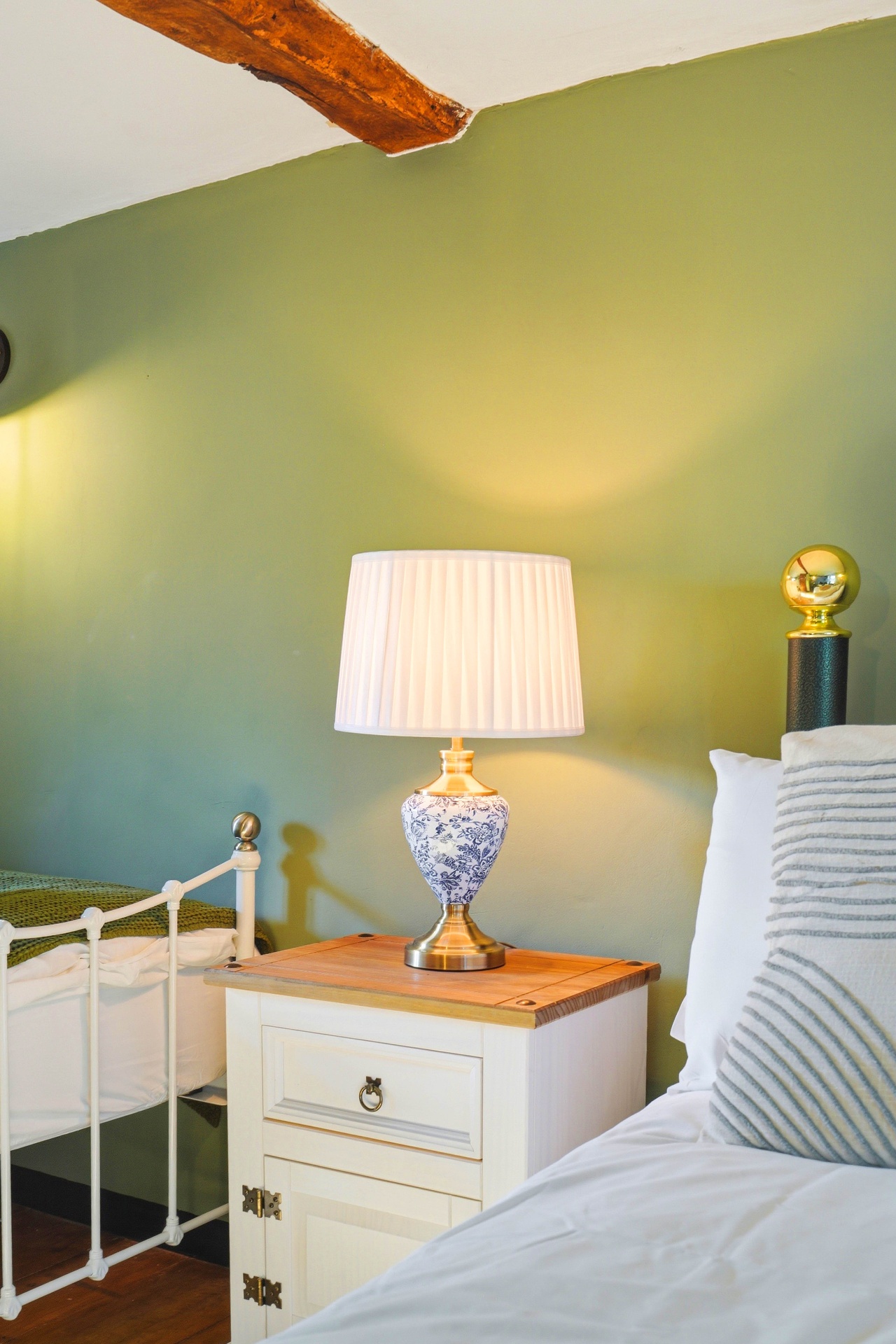 Bedside detail in Bedroom Two with floral lamp and antique table