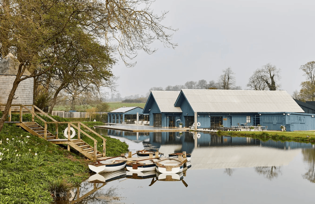 Soho Farmhouse boathouse with rowing boats on the lake